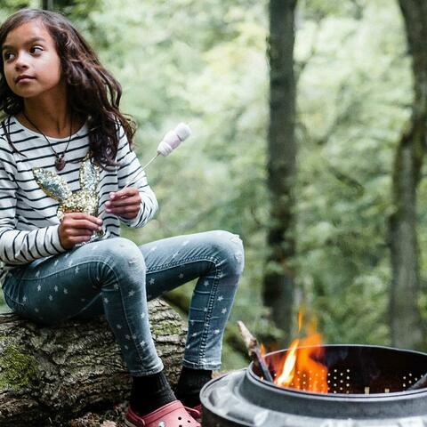 Girl roasts marshmallows in woodland