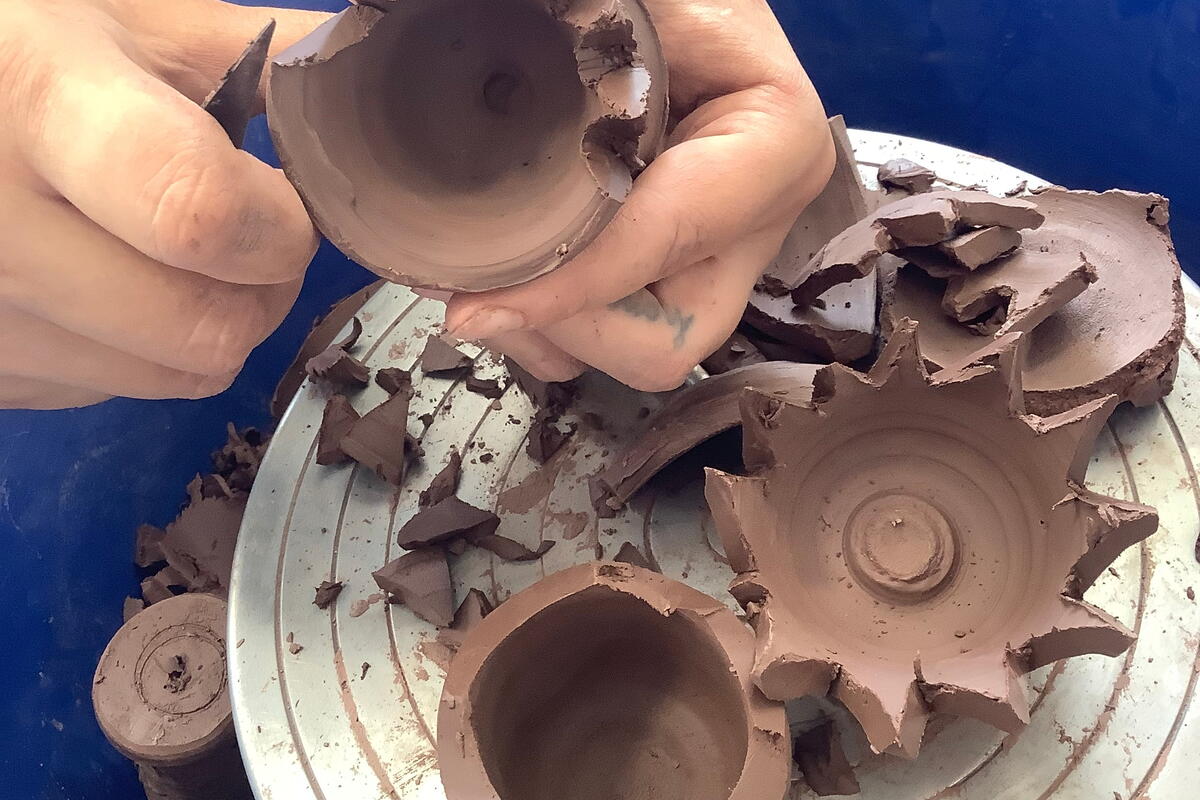 turned clay pots being carved with tools
