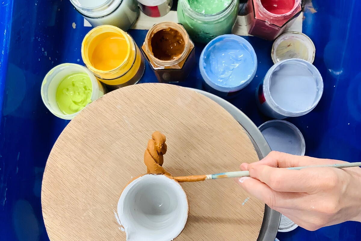 Turned clay pots being glazed
