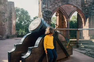 Girl hiding behind cannon at Goodrich Castle