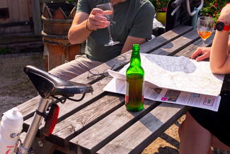 Couple looking over map with cider in hands