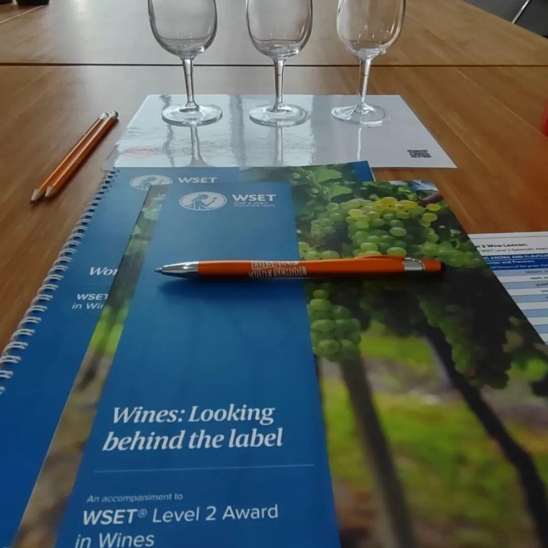 textbook with empty wine glasses and pen