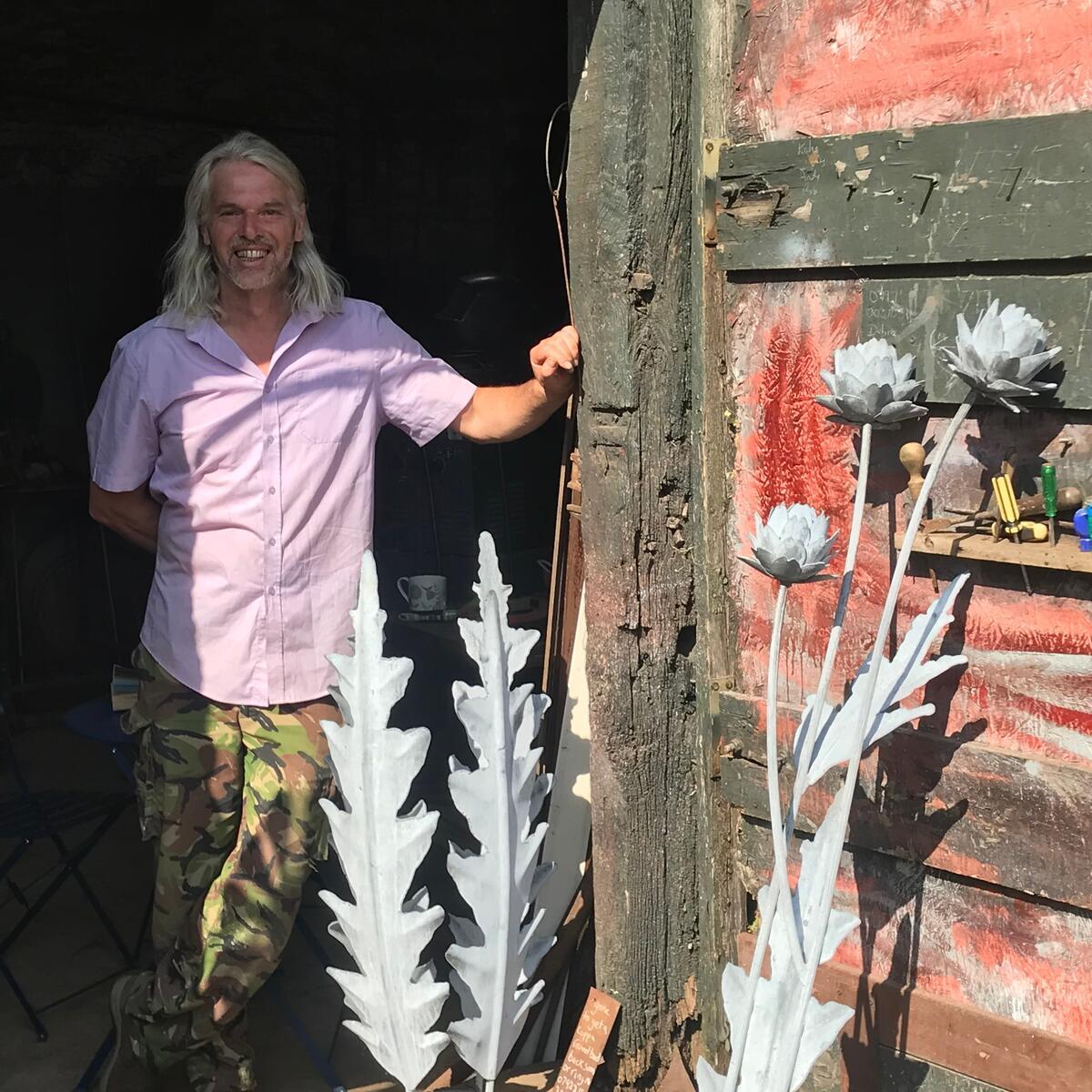 man with pewter sculptures in organic long leaf-like designs