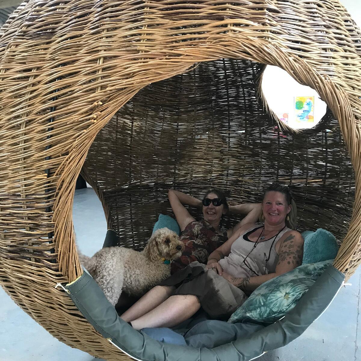 people sat in a woven hanging swing chair