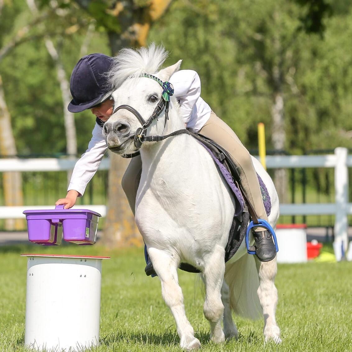 child on a white pony at event