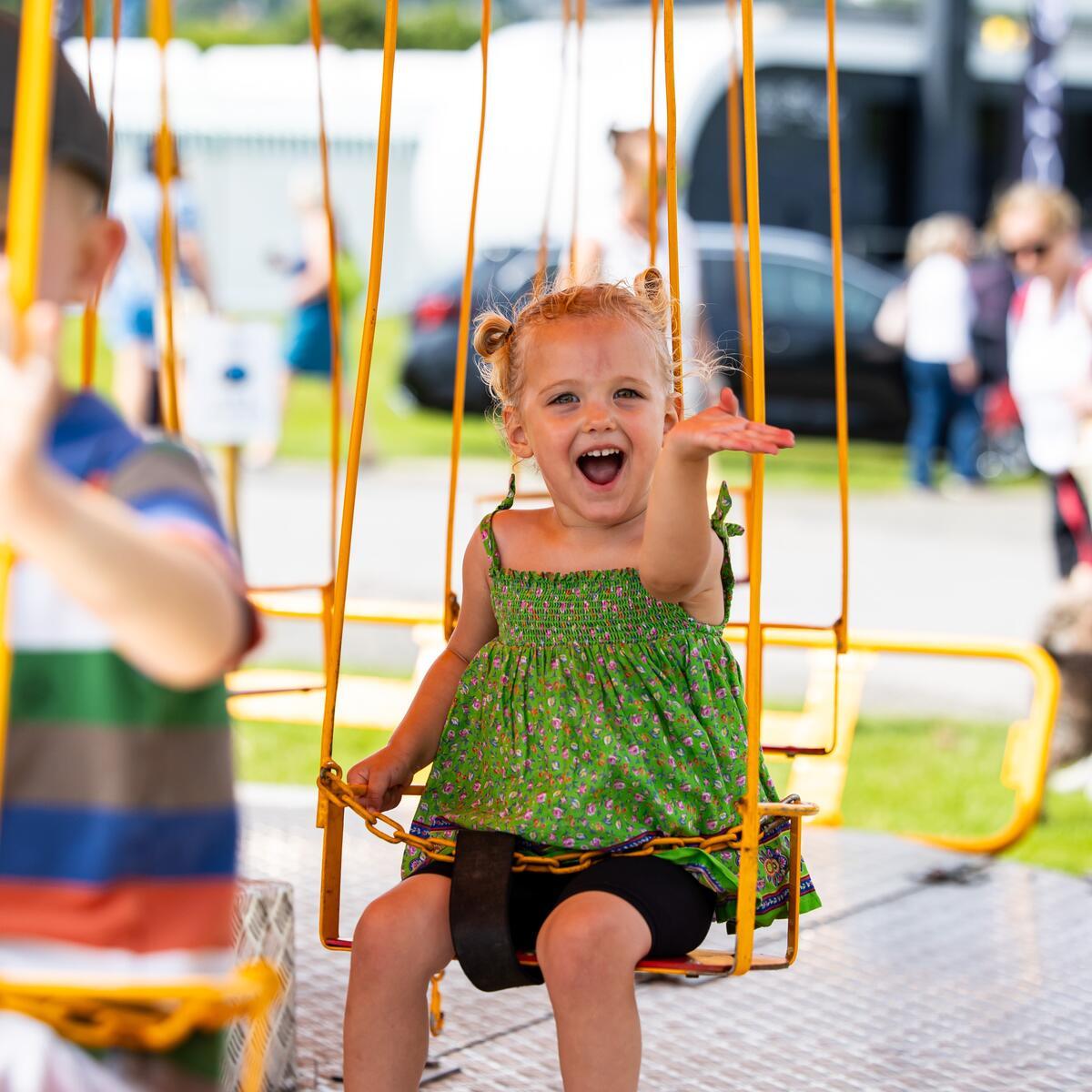 a child on a fairground swing ride