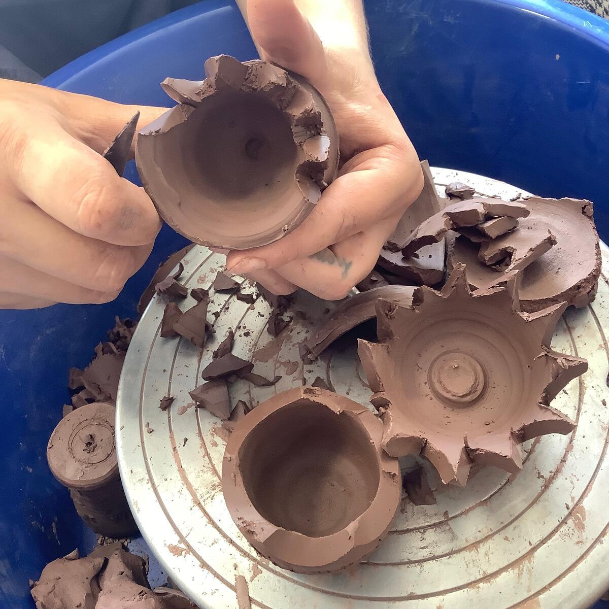 turned clay pots being carved with tools