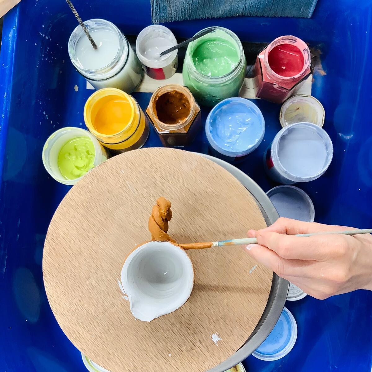 Turned clay pots being glazed