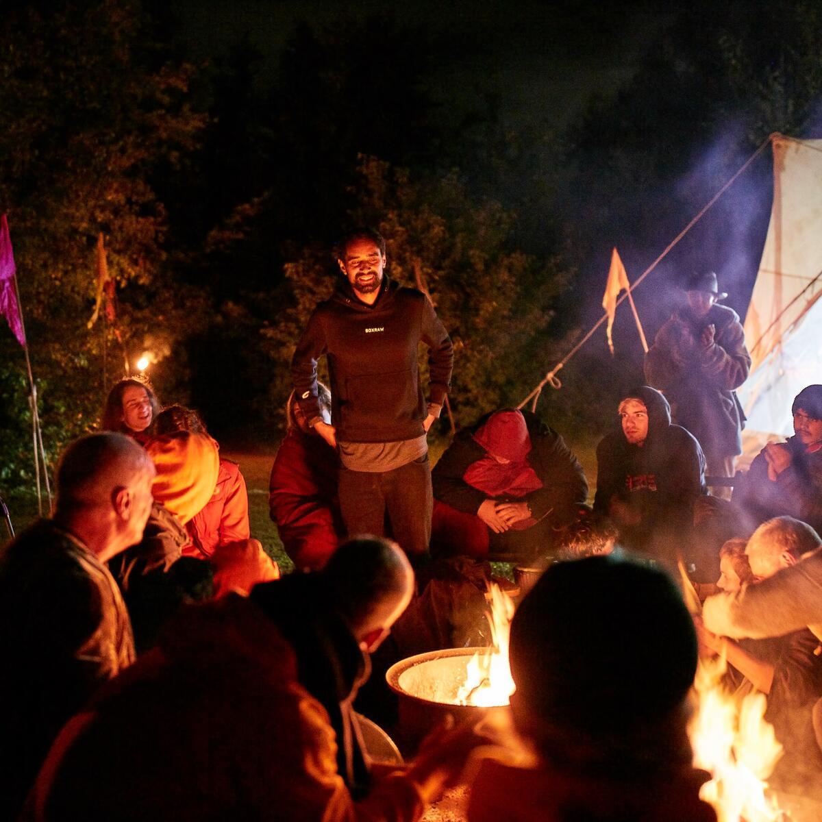 People sat around a firepit at night