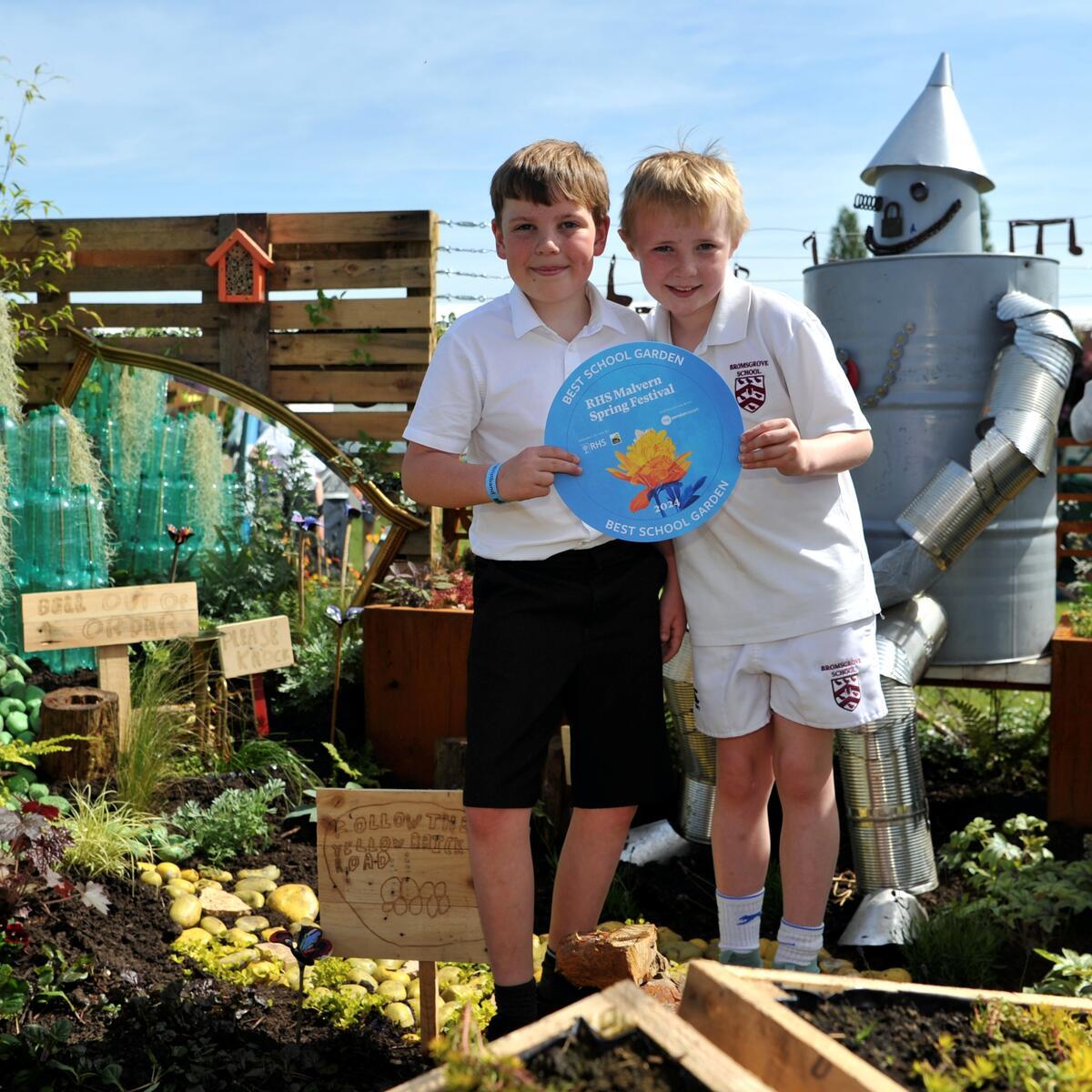 Children with a certificate in a garden at the RHS Malvern Spring show 