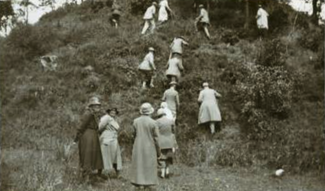 Old photograph showing members of the old straight club climbing a steep mound