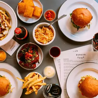 burgers and chips on plates on table with menus