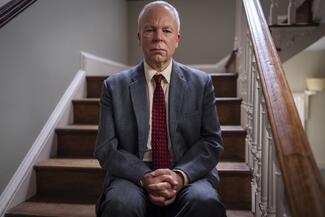 Actor Steve Pemberton sat on a stairs in a historic house