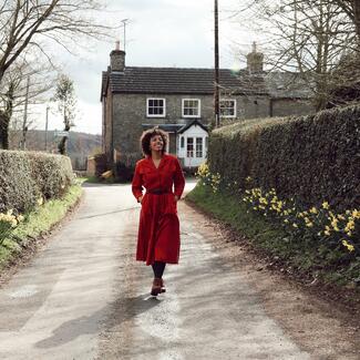 person walking along country lane with daffodils