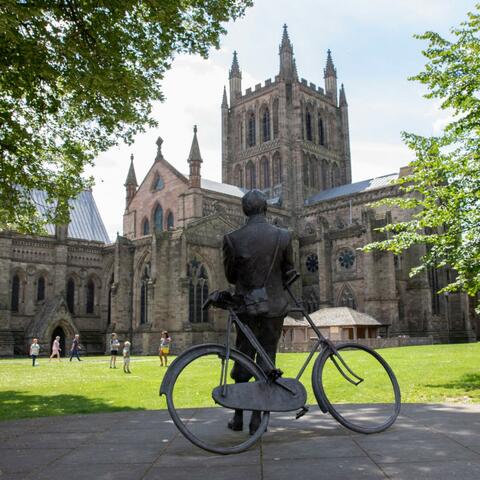 Statue of Elgar with his bicycle looking up at the Cathedral