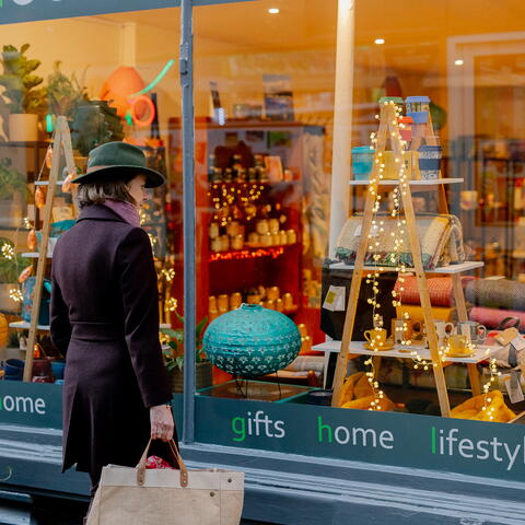 Woman looking through Christmassy shop window