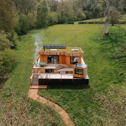 scandi cabin set in amongst fields and woodland