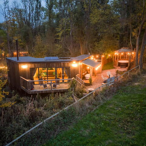 A sprawling treehouse cabin lit up by fairy lights