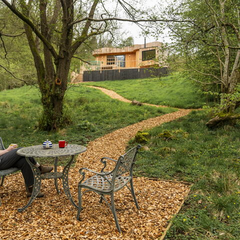 A woman sits at a table outside