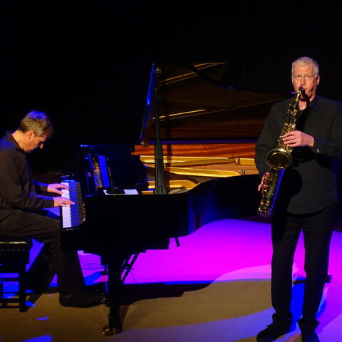 Man playing piano and man playing saxaphone