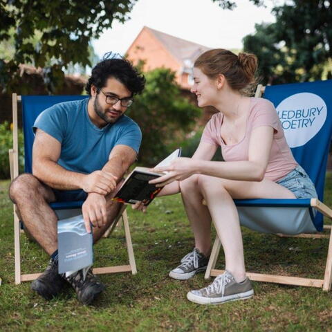 couple on deckchairs reading a book