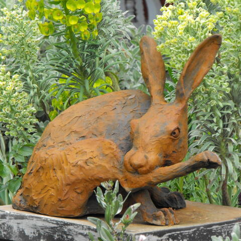 sculpture of hare biting on its back leg