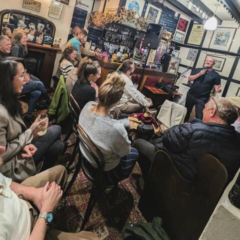 Crowd watching live performance inside country pub