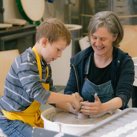 Adult and child at potter's wheel