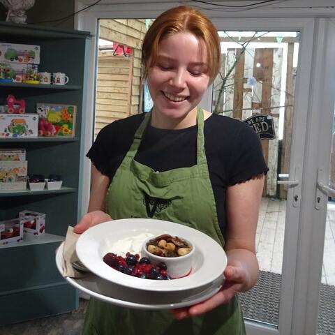 Waitress serving Granola breakfast in the Nest cafe 