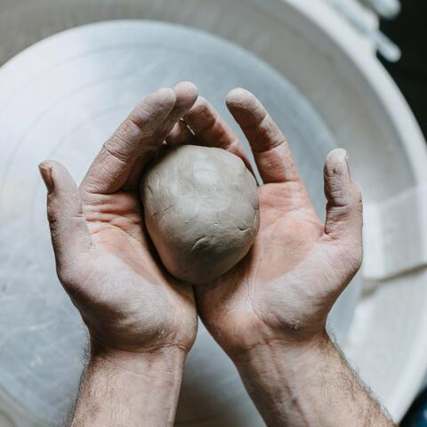 Hands holding a ball of clay