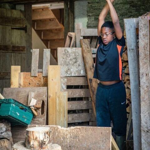 Young person chopping a log with an axe