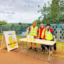 people in hi vis jackets by a trestle table outdoors 