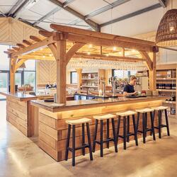 wooden bar in the centre of a large converted barn style building