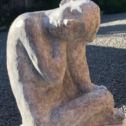 stone sculpture of a figure sitting