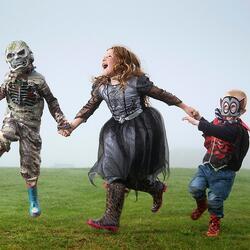 three children dressed in halloween costumes