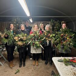 Group of people holding handmade Christmas wreaths