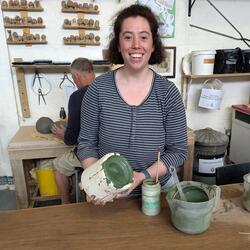 Lady holding a pot with grey clay slip