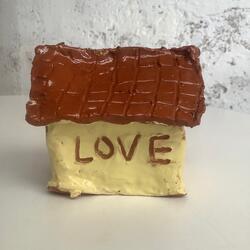 clay house with the word 'love' carved into it