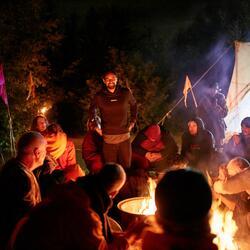 People sat around a firepit at night