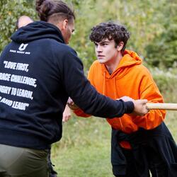 Two young people wrestling over a stick