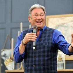 Alan Titchmarsh holding a microphone